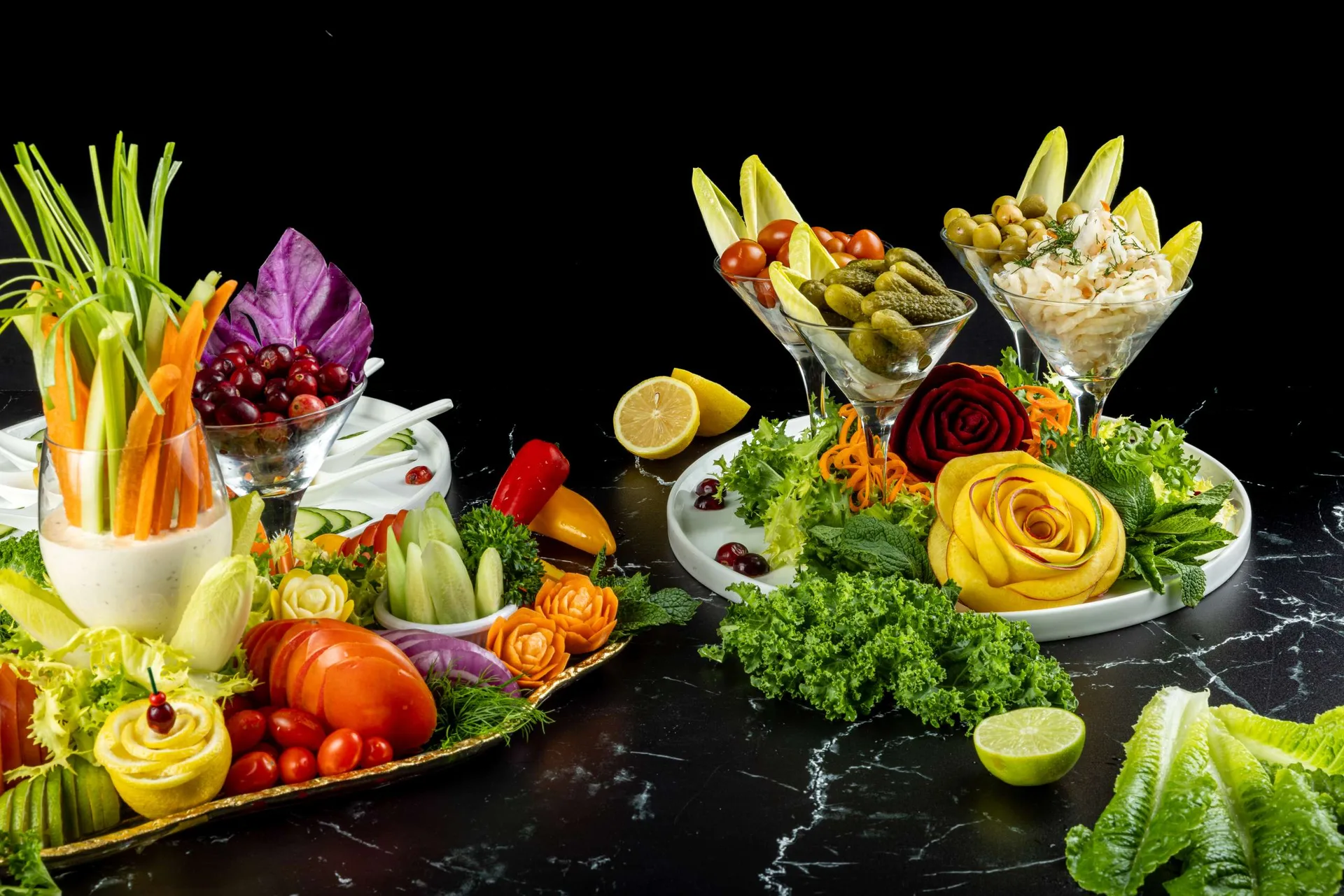 Una torre de crudités con albahaca morada, copas de aceitunas, pepinillos y ensalada de col, y una rosa de calabacín amarillo en un plato blanco