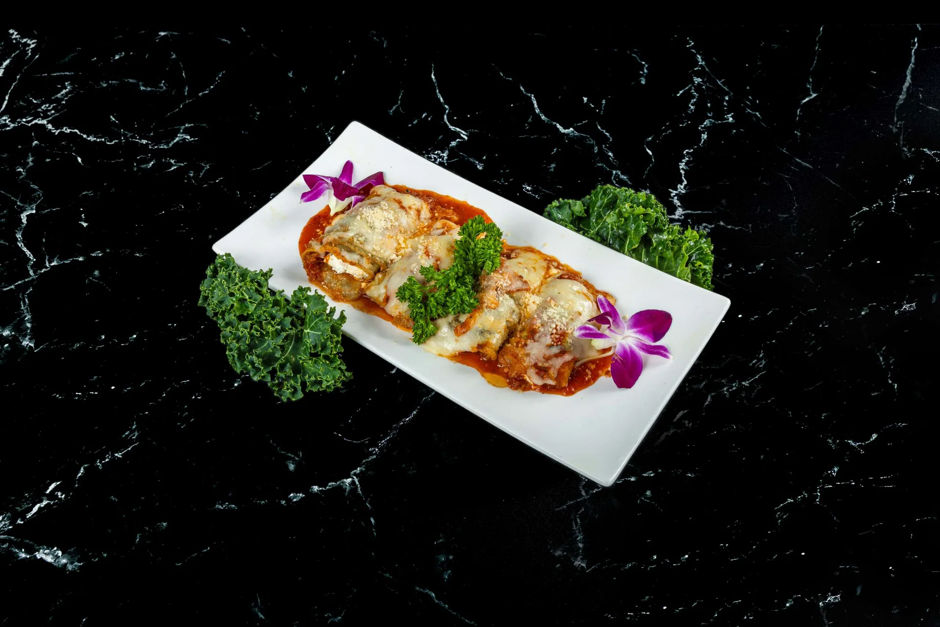 Conchas de pasta rellenas en salsa de tomate con queso fundido en una fuente rectangular