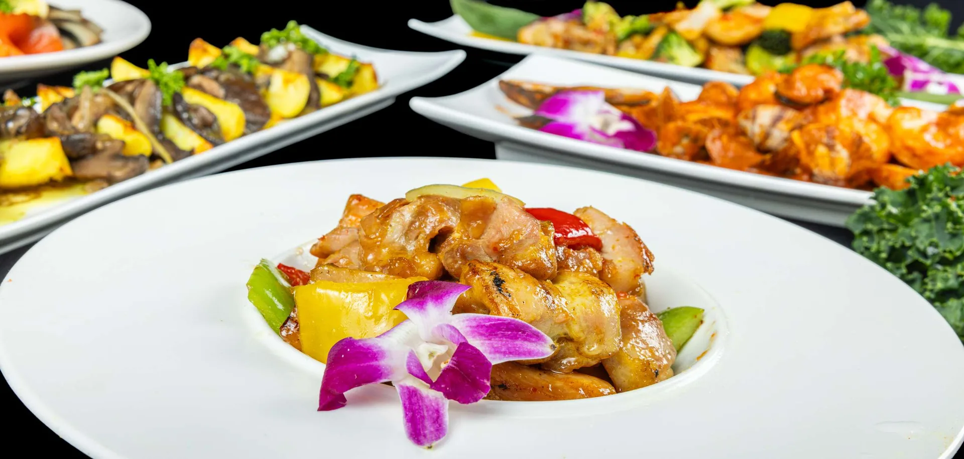 Pollo en salsa agridulce con pimientos y piña, con más fuentes de servicio al fondo