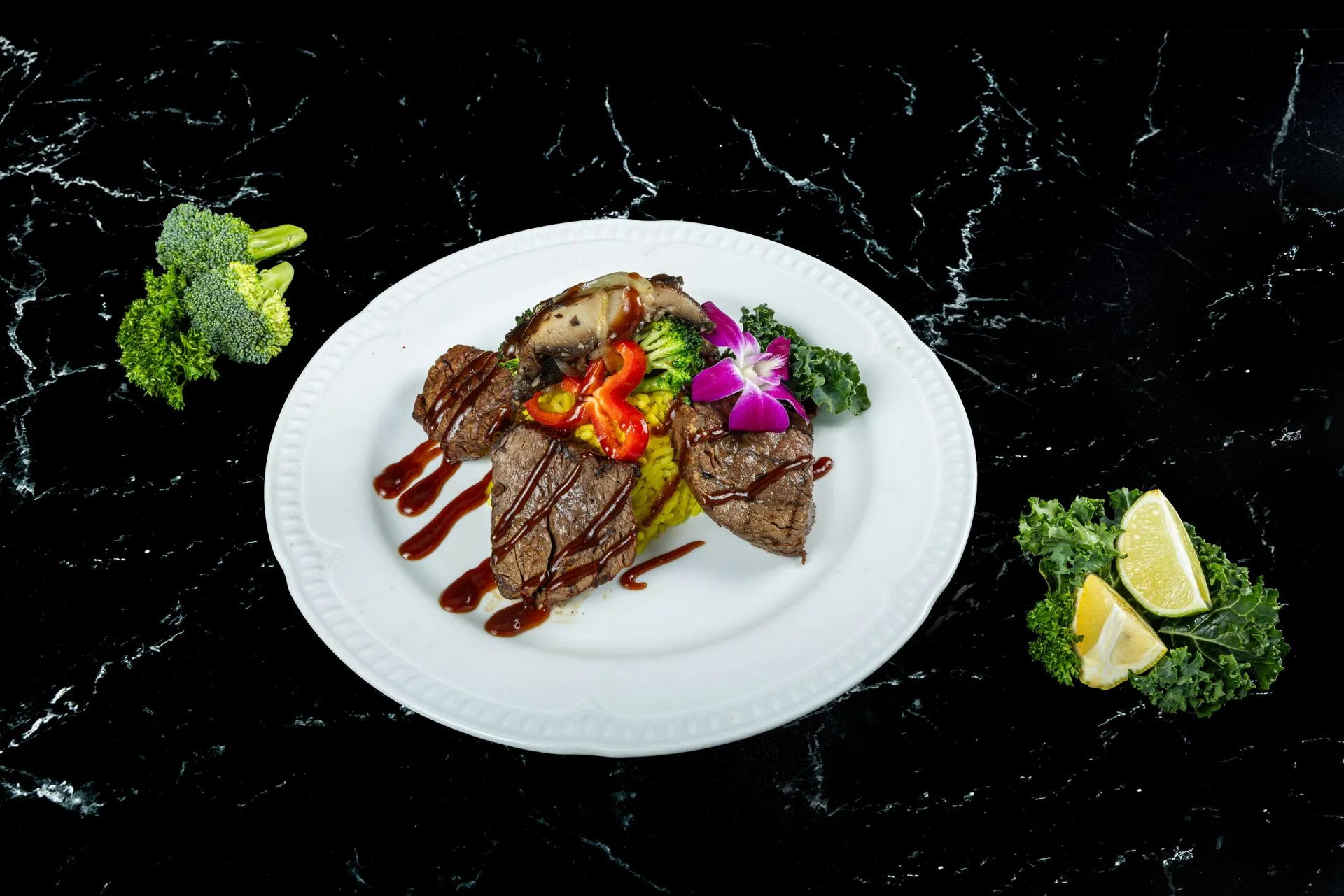 Filete en lonchas con verduras a la parrilla en un plato blanco redondo, con reducción de vino tinto
