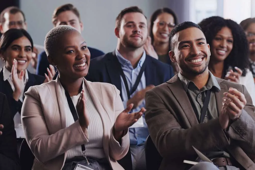 Business people, conference and audience applause at seminar, workshop or training. Diversity men and women crowd clapping at presentation or convention for corporate success, bonus or growth.