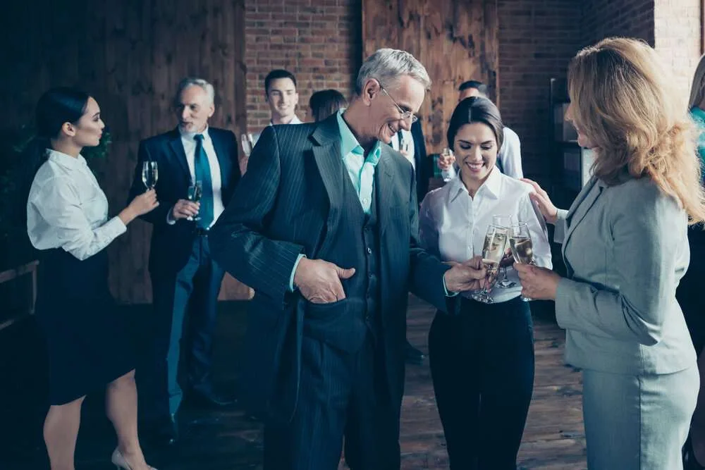 Business crowd say toasts congrats formal wear jackets shirts.