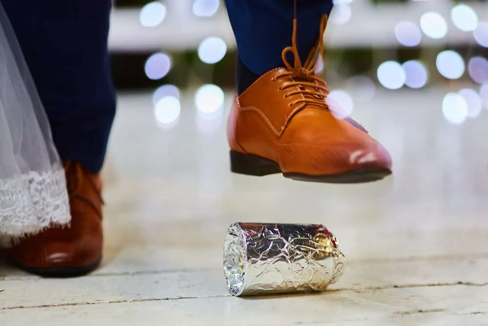 Groom breaking a glass at a Jewish wedding stamping it underfoot symbolizing the destruction of the temple in Jerusalem, close up of the right foot