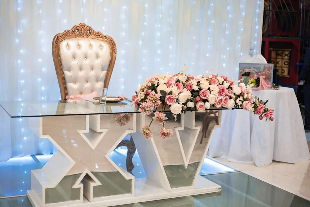 Quinceañera table for guest of honor, roman numerals X and V symbolizing 15, the age of quinceanera celebration