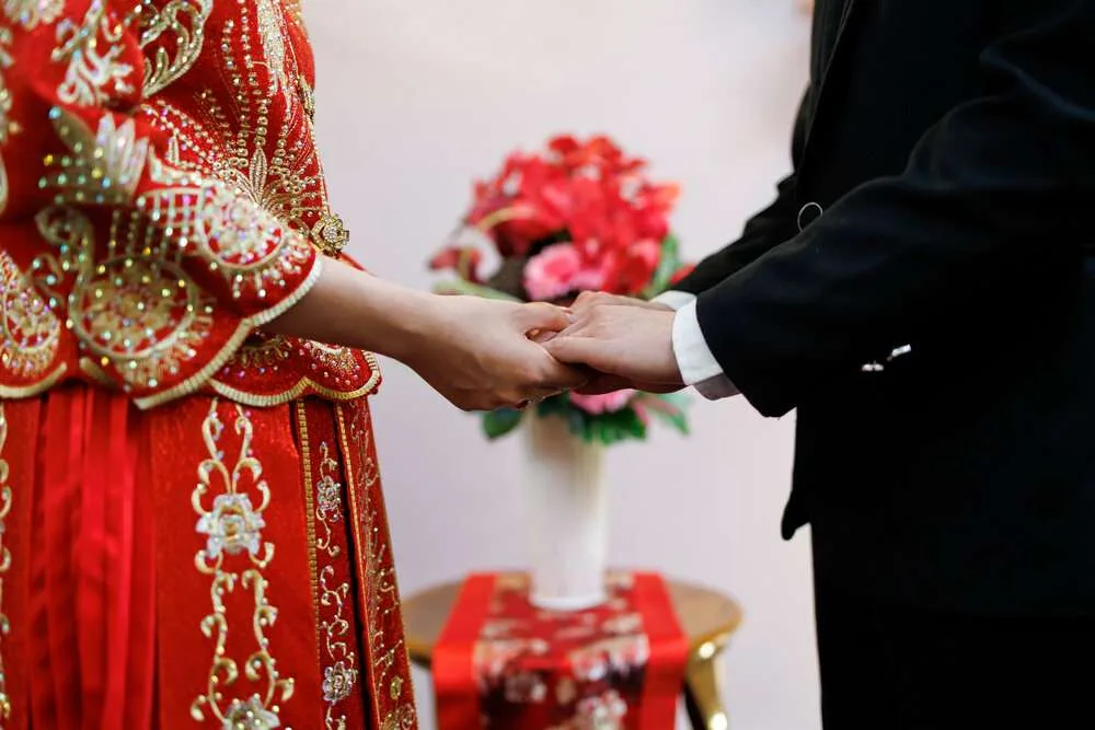 Soft focus image of groom and bride holding hands, multicultural wedding ceremony