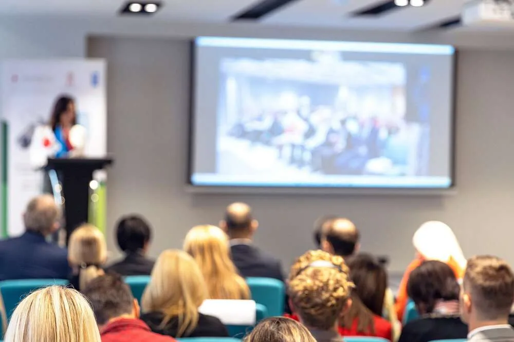 Business conference or international political meeting. Hybrid event, attendees both in person and virtually